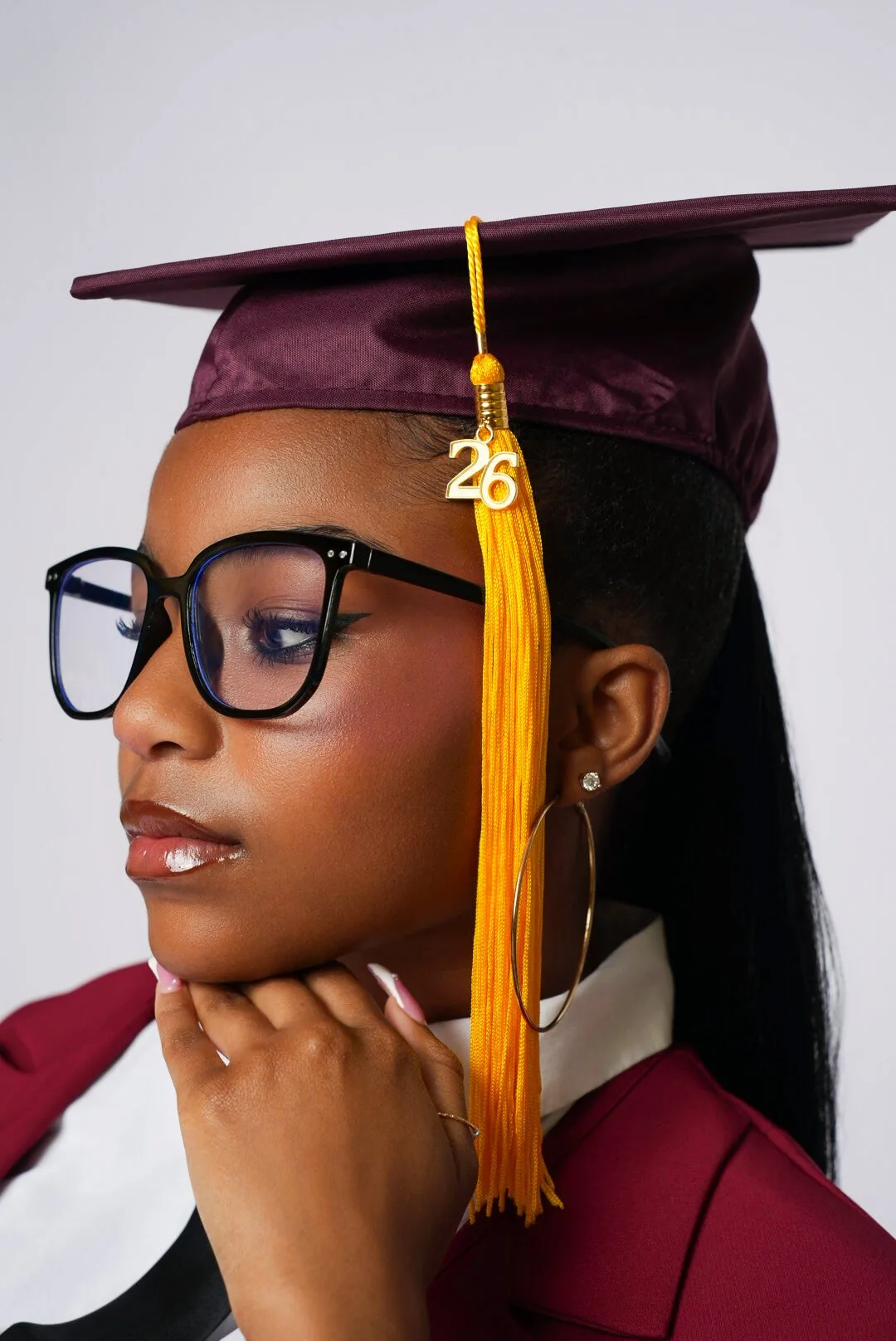 Close-up graduation portrait in a burgundy cap and gown