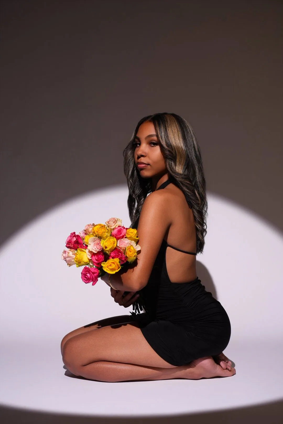 Studio portrait of a woman holding a vibrant bouquet