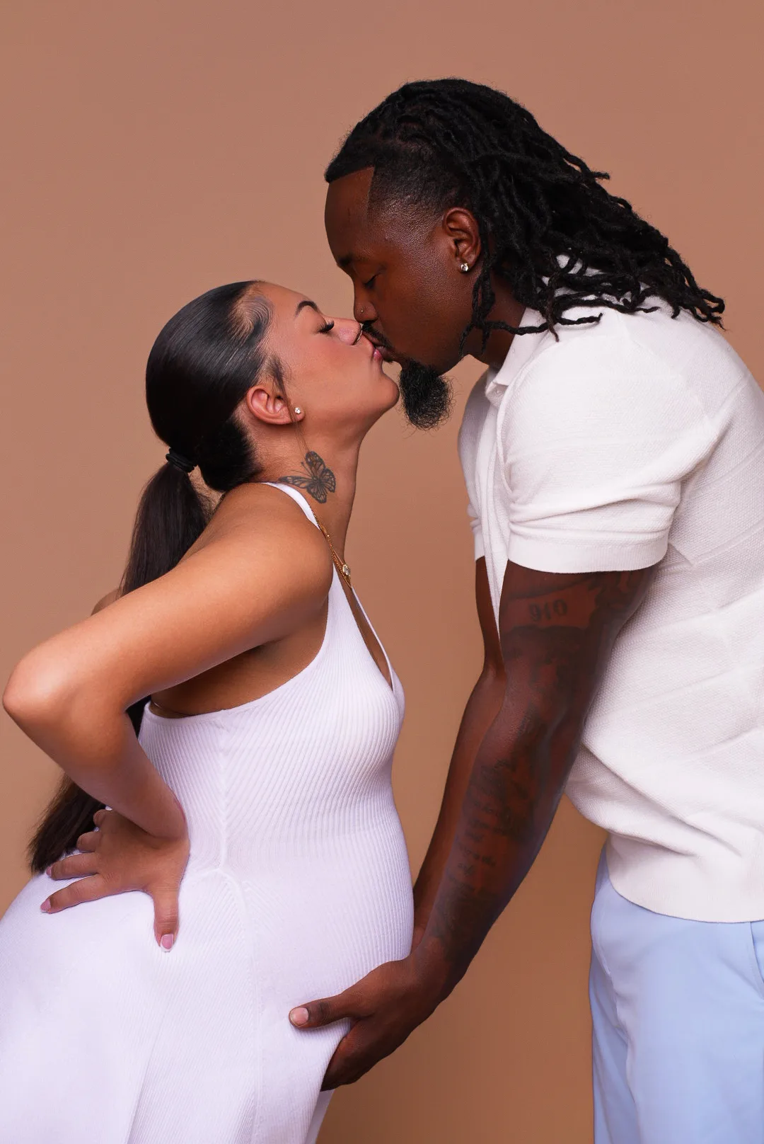 Maternity portrait of a couple in coordinated white outfits